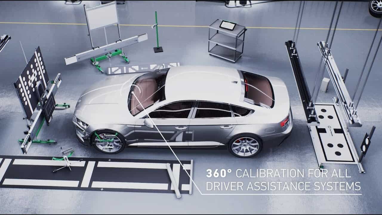 A silver sedan is surrounded by calibration equipment in a high-tech workshop, with text reading "360° CALIBRATION FOR ALL DRIVER ASSISTANCE SYSTEMS." Tools and platforms, including those for windshield replacement, are meticulously arranged around the vehicle.