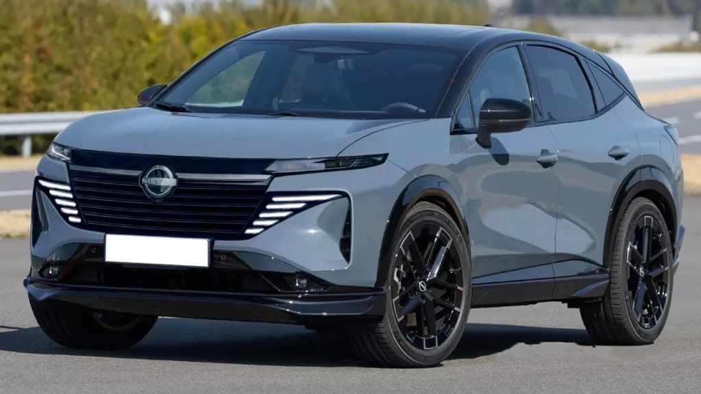 A sleek, modern gray SUV with black accents and tinted windows is parked on a road, surrounded by greenery and clear skies in the background.
